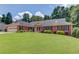 Charming brick home featuring a well-maintained lawn and colorful landscaping, complemented by black shutters at 3550 Miller Farms Ln, Peachtree Corners, GA 30096