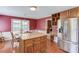 Open kitchen and dining area with stainless steel refrigerator and island, hardwood floors, and updated cabinets at 3550 Miller Farms Ln, Peachtree Corners, GA 30096