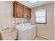 Convenient laundry room with washer, dryer, utility sink, and storage cabinets at 3550 Miller Farms Ln, Peachtree Corners, GA 30096