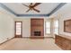 Bright living room boasts a charming brick fireplace, ceiling fan, and a door to the outside at 3550 Miller Farms Ln, Peachtree Corners, GA 30096
