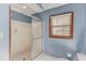 Clean bathroom with a standup shower with glass door, a window, and neutral walls at 3550 Miller Farms Ln, Peachtree Corners, GA 30096