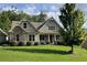 Charming home featuring a stone facade, covered porch, manicured lawn, and mature landscaping at 37 Grand Georgian Ne Ct, Cartersville, GA 30121