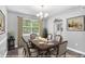 Virtually staged dining room with modern chandelier and large window at 2722 Spring Side Ct, Douglasville, GA 30135