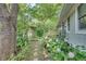 Landscaped home exterior with stone pathway, flowers, and mature trees surrounding the property at 4621 Lakeshore Dr, Pine Lake, GA 30072