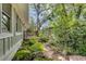Lush landscaped yard with a stone pathway and mature trees surrounding the home at 4621 Lakeshore Dr, Pine Lake, GA 30072