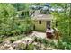 Exterior view of the home with a wooden deck, lush landscaping, and mature trees at 4621 Lakeshore Dr, Pine Lake, GA 30072