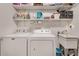Functional laundry room with washer, dryer, sink, and ample shelving for storage solutions at 4621 Lakeshore Dr, Pine Lake, GA 30072