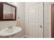 Bathroom featuring a pedestal sink, framed mirror, and a door to the walk-in shower at 47 Oakridge Se Ave, Atlanta, GA 30317