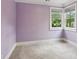 Cozy bedroom with natural light from two windows and neutral-colored carpet and walls at 47 Oakridge Se Ave, Atlanta, GA 30317