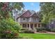 Charming two-story home with a covered front porch surrounded by lush landscaping at 47 Oakridge Se Ave, Atlanta, GA 30317
