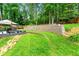 Beautiful terraced backyard with landscaped yard, lush trees and stone retaining wall at 1050 Lake Charles Dr, Roswell, GA 30075