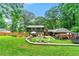 Aerial view of backyard with deck, patio, fire pit, and mature trees at 1050 Lake Charles Dr, Roswell, GA 30075