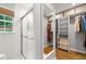 Bathroom featuring glass shower, walk-in closet with built-in shelving and window at 1050 Lake Charles Dr, Roswell, GA 30075