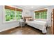 Cozy bedroom with hardwood floors, natural light, and a large window showcasing the outdoor landscape at 1050 Lake Charles Dr, Roswell, GA 30075