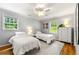 Neutral bedroom with two twin beds, a ceiling fan, hardwood floors, and natural light at 1050 Lake Charles Dr, Roswell, GA 30075