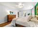 Bright bedroom featuring hardwood floors, white walls, ceiling fan, and neutral bedding at 1050 Lake Charles Dr, Roswell, GA 30075