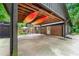 Spacious carport with kayaks above, leading to an outdoor patio area and fenced yard at 1050 Lake Charles Dr, Roswell, GA 30075