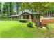 Charming brick home with mature trees, manicured lawn and side entrance, highlighting outdoor space at 1050 Lake Charles Dr, Roswell, GA 30075