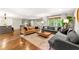 Bright living room with hardwood floors, multiple couches, a coffee table, and large windows with natural light at 1050 Lake Charles Dr, Roswell, GA 30075