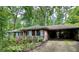 Charming single story brick house with carport and front porch nestled among mature trees at 1333 Council Bluff Ne Dr, Atlanta, GA 30345