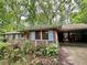 Charming single story brick house with carport and front porch nestled among mature trees at 1333 Council Bluff Ne Dr, Atlanta, GA 30345