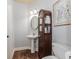 Charming powder room with pedestal sink, decorative cabinet, and wood flooring at 2727 Bearcreek Pl, Buford, GA 30519