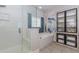 Bright bathroom featuring a glass-enclosed shower, soaking tub, storage cabinet, and decorative mural at 2727 Bearcreek Pl, Buford, GA 30519