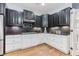 Well-lit kitchen featuring black upper cabinets, white lower cabinets, hardwood floors, and sleek countertops at 2727 Bearcreek Pl, Buford, GA 30519