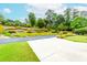 Beautiful landscaping featuring mature trees, colorful flower beds, and lush green grass near the driveway at 2727 Bearcreek Pl, Buford, GA 30519