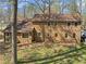 Expansive view of home featuring tan siding, a welcoming back door, and a well-maintained lawn with mature trees at 4354 Revere Cir, Marietta, GA 30062
