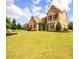Lovely brick home featuring manicured lawn, beautiful landscaping, and shuttered windows at 6110 Read Rd, Suwanee, GA 30024