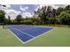 Community tennis court surrounded by trees and landscaping offers great recreation at 6110 Read Rd, Suwanee, GA 30024