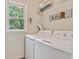 Functional laundry room with washer, dryer, wire shelving, and a window offering natural light at 3605 Hickory Se Cir, Smyrna, GA 30080