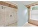 Walk in shower with a frosted glass partition, decorative tile, and window for natural light at 3605 Hickory Se Cir, Smyrna, GA 30080