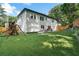 Spacious backyard featuring lush green grass, a playset, outdoor seating, and a wooden fence at 3899 Carlton Dr, Chamblee, GA 30341