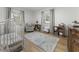 Bright Bedroom features a charming rug, light gray walls, and a crib next to a window at 3899 Carlton Dr, Chamblee, GA 30341