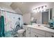 Bathroom features a unique shower curtain, a bright vanity with white cabinets, and a large mirror at 501 Avery Creek Pointe, Woodstock, GA 30188