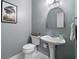 Charming powder room with a pedestal sink, decorative mirror, and soothing paint color at 501 Avery Creek Pointe, Woodstock, GA 30188