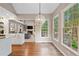 Sunlit dining area showcasing wood floors, a modern light fixture, and large windows at 501 Avery Creek Pointe, Woodstock, GA 30188
