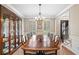 Formal dining room features a large table, elegant chandelier, and ample natural light, perfect for gatherings at 501 Avery Creek Pointe, Woodstock, GA 30188