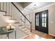 Elegant foyer showcases a staircase, hardwood floors, and a stylish front door, setting a sophisticated tone at 501 Avery Creek Pointe, Woodstock, GA 30188