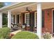Relaxing porch with white columns, a porch swing, and comfortable seating offers a perfect spot for leisure at 501 Avery Creek Pointe, Woodstock, GA 30188