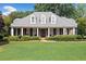 Charming single-story home boasts a manicured lawn, a brick porch, and classic architectural details at 501 Avery Creek Pointe, Woodstock, GA 30188