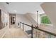 Bright hallway with neutral walls, plush carpet, and a large window offering a view of lush greenery at 501 Avery Creek Pointe, Woodstock, GA 30188