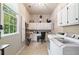 Well-lit laundry room with ample storage, built-in desk area, and modern washer and dryer at 501 Avery Creek Pointe, Woodstock, GA 30188