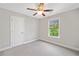 Well lit bedroom with carpet, a ceiling fan, and a view of the greenery outside the window at 115 Greenbrier Way, Canton, GA 30114