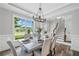 Bright dining room featuring a modern chandelier, stairs, and a view of the front yard at 115 Greenbrier Way, Canton, GA 30114