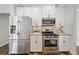 Modern kitchen features stainless appliances, granite countertops, and white cabinetry at 115 Greenbrier Way, Canton, GA 30114