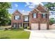 Inviting brick home featuring a well-kept lawn, manicured landscaping and a two-car garage at 3024 Bridgehaven Ct, Snellville, GA 30039