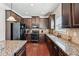 Well-equipped kitchen with stainless steel appliances, granite countertops and dark wood cabinetry at 3024 Bridgehaven Ct, Snellville, GA 30039